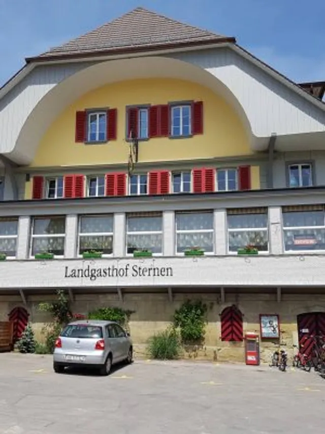 Aussenansicht des Landgasthofs Sternen mit gelber Fassade und roten Fensterläden