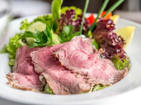 Roastbeef in dünnen Scheiben, angerichtet auf einem bunten Salatbett